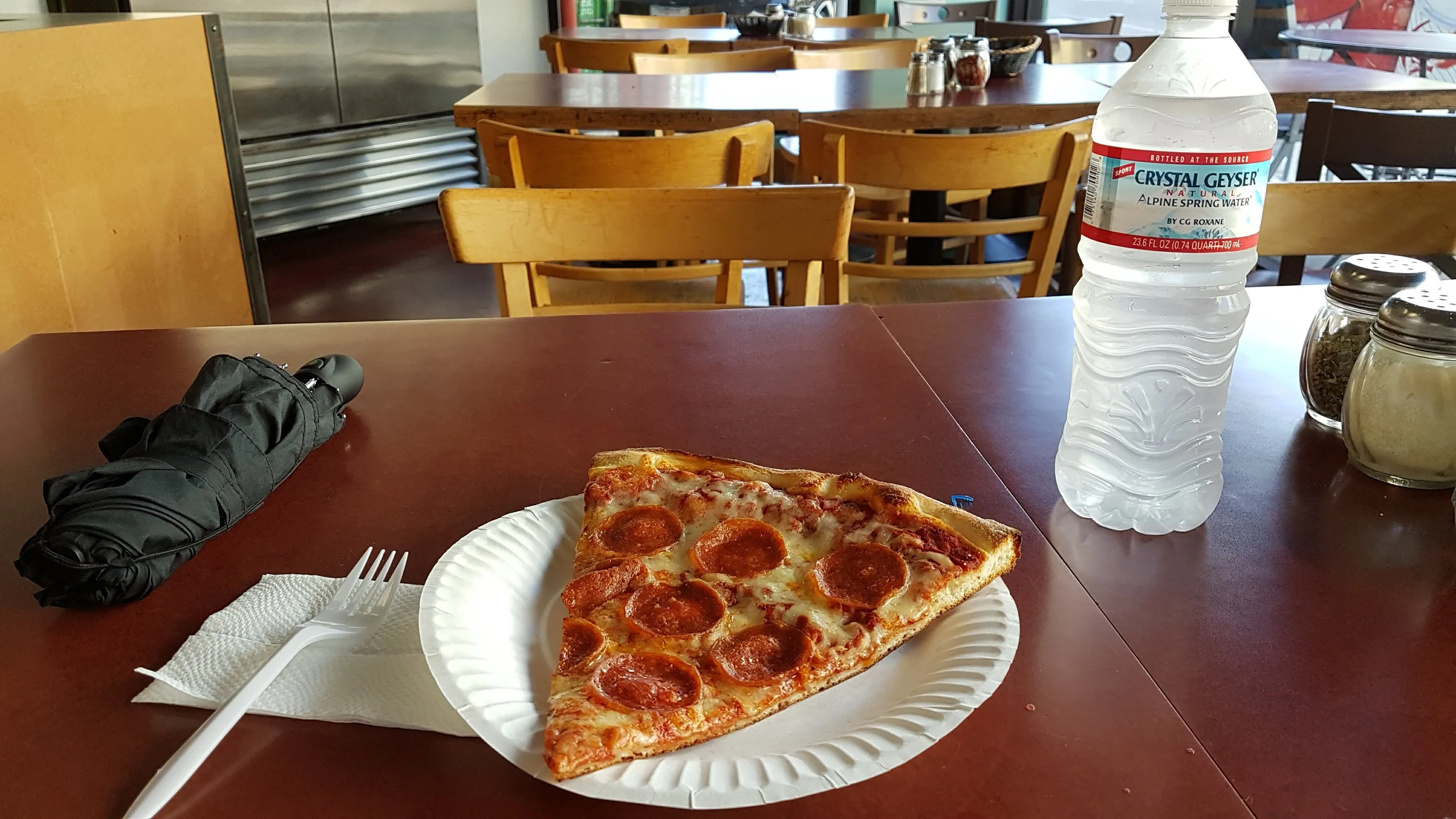 A slice of pizza on a paper plate